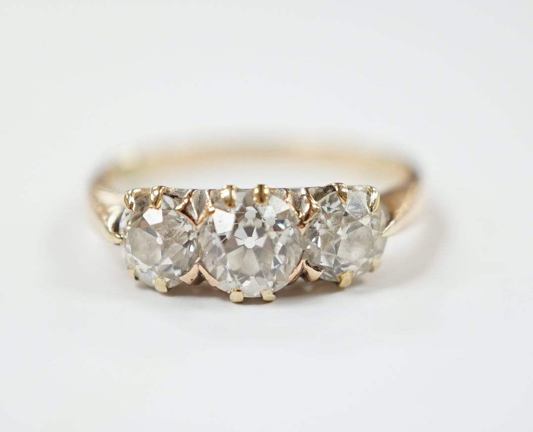 A yellow metal and three stone diamond set ring, size P, gross weight 2.6 grams.